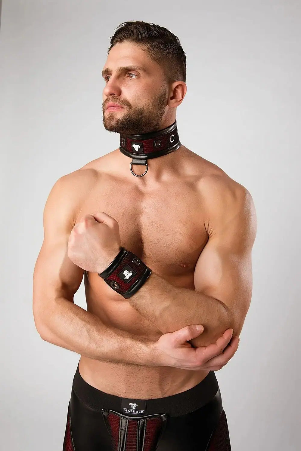 Maskulo red fetish play collar for men with black mesh, PU leather piping, and large metal grommets, appealing to leather fetish style and puppies subculture