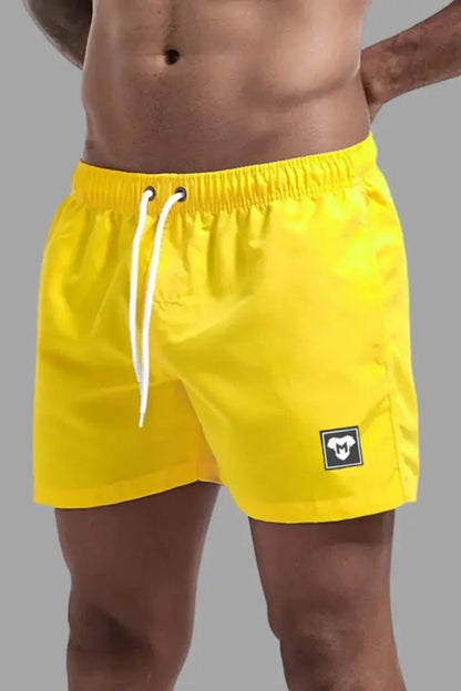 Maskulo Triton Cyclone Yellow Shorts: soft-touch nylon/polyester, white mesh lining, free fit, 3 pockets. Global shipping from EU.